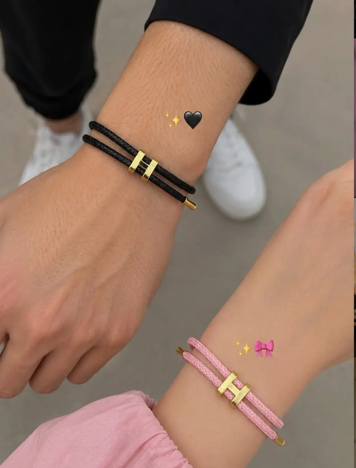 Matching black and pink leather cord bracelets with gold accents on two wrists.