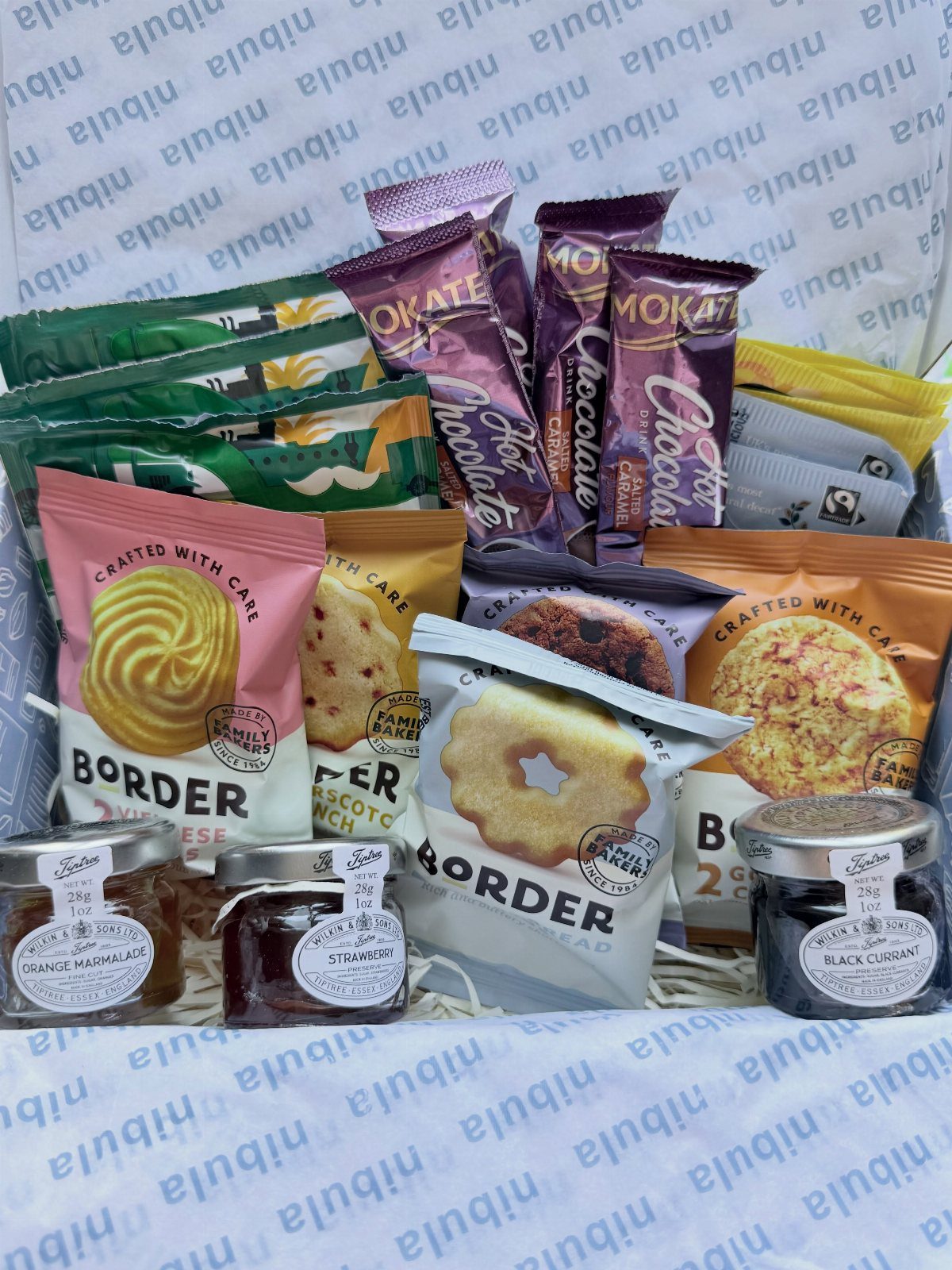British snack box containing Border biscuits, chocolate bars, and small jam jars.