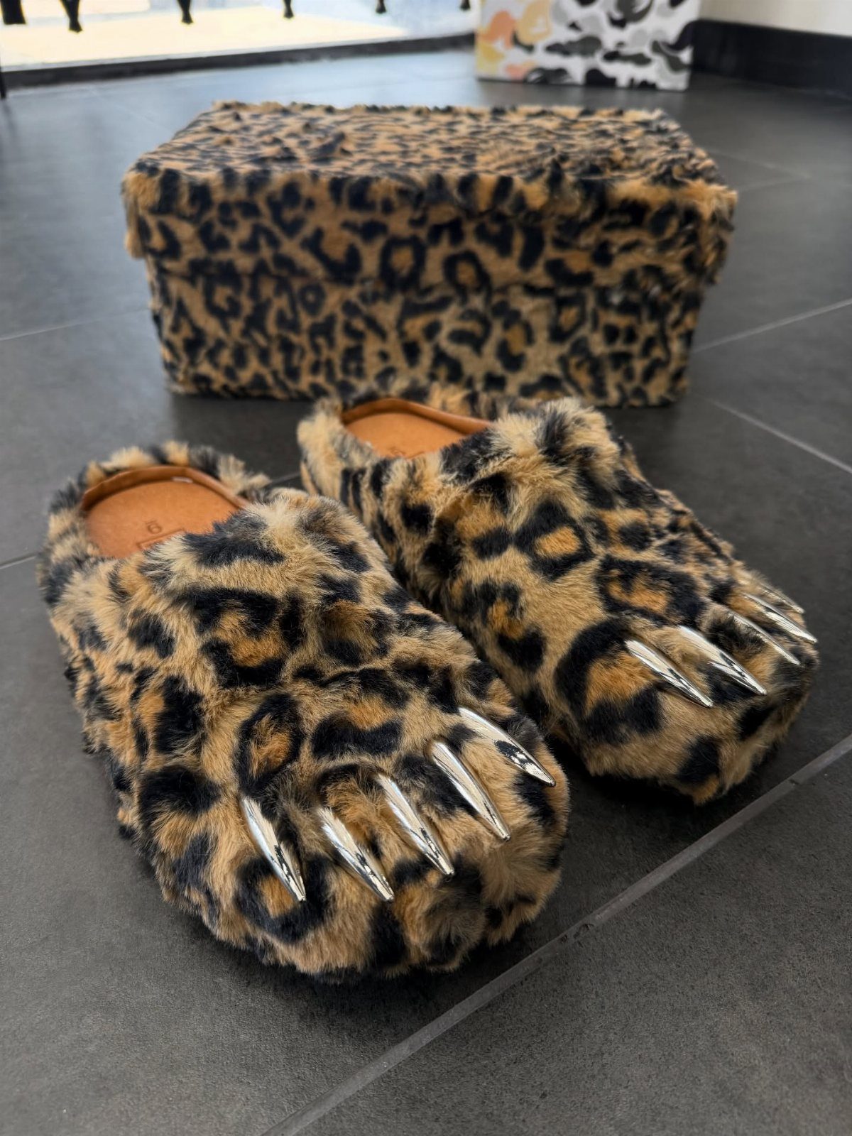 Leopard print fluffy slider slippers with silver claws and a matching storage box.