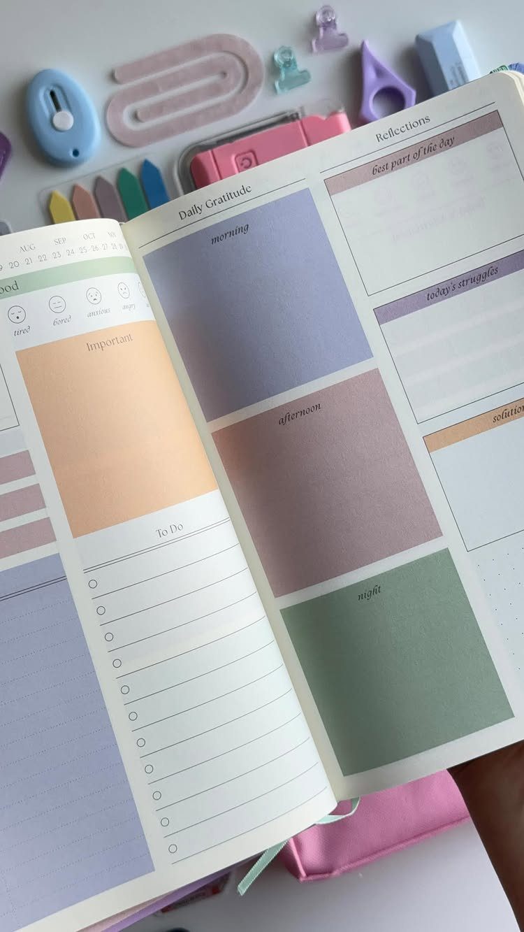 Open gratitude journal with pastel sections and colorful stationery on a white background