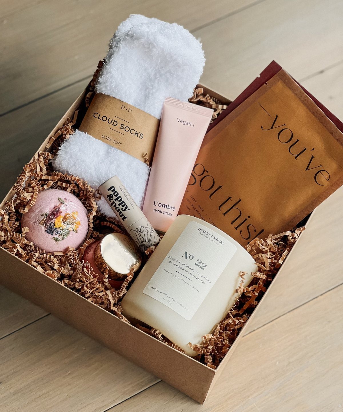 Self-care gift box with fluffy socks, candle, bath bomb, and motivational card.