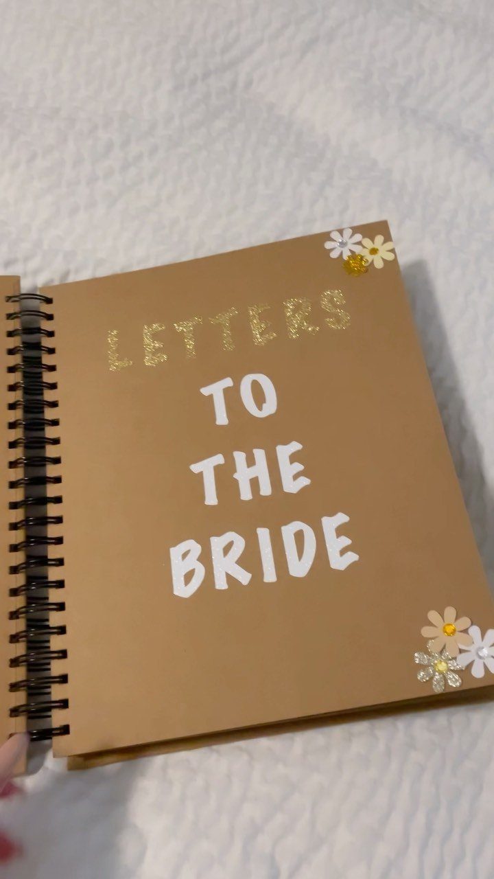 Brown spiral book with Letters to the Bride text and daisy flower decorations.