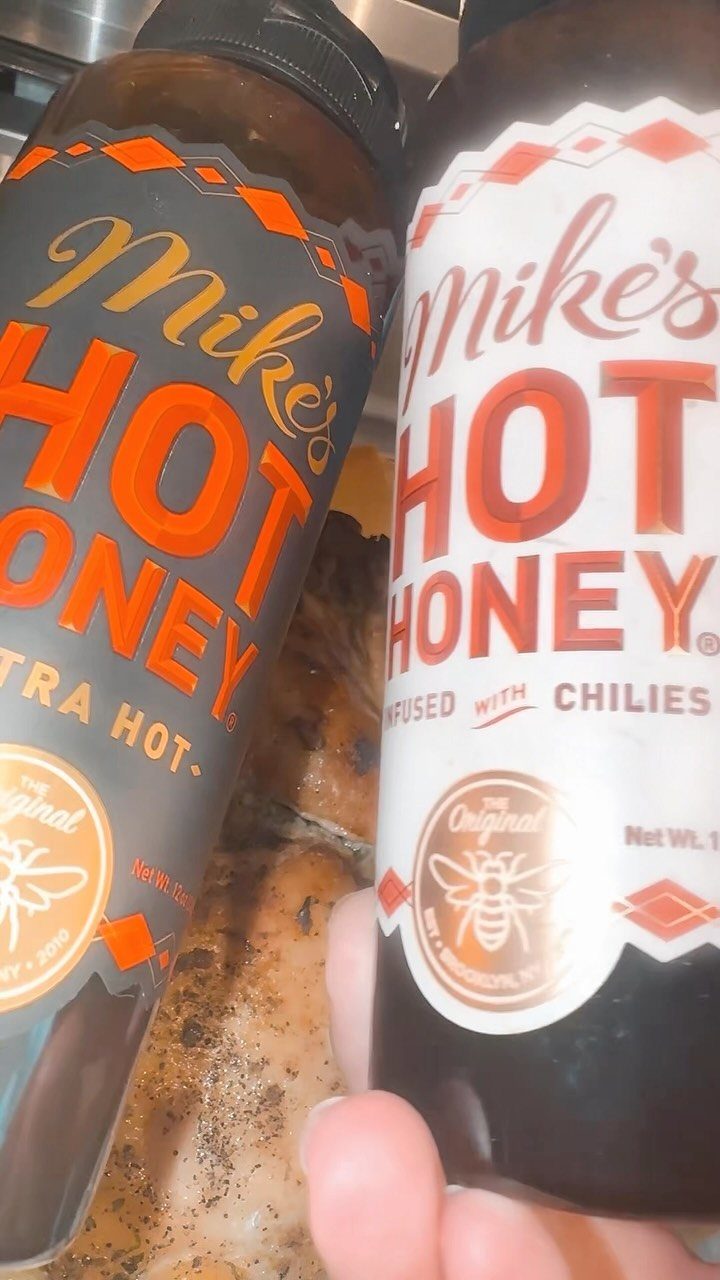 Two bottles of Mike's Hot Honey, one original and one extra hot variety.