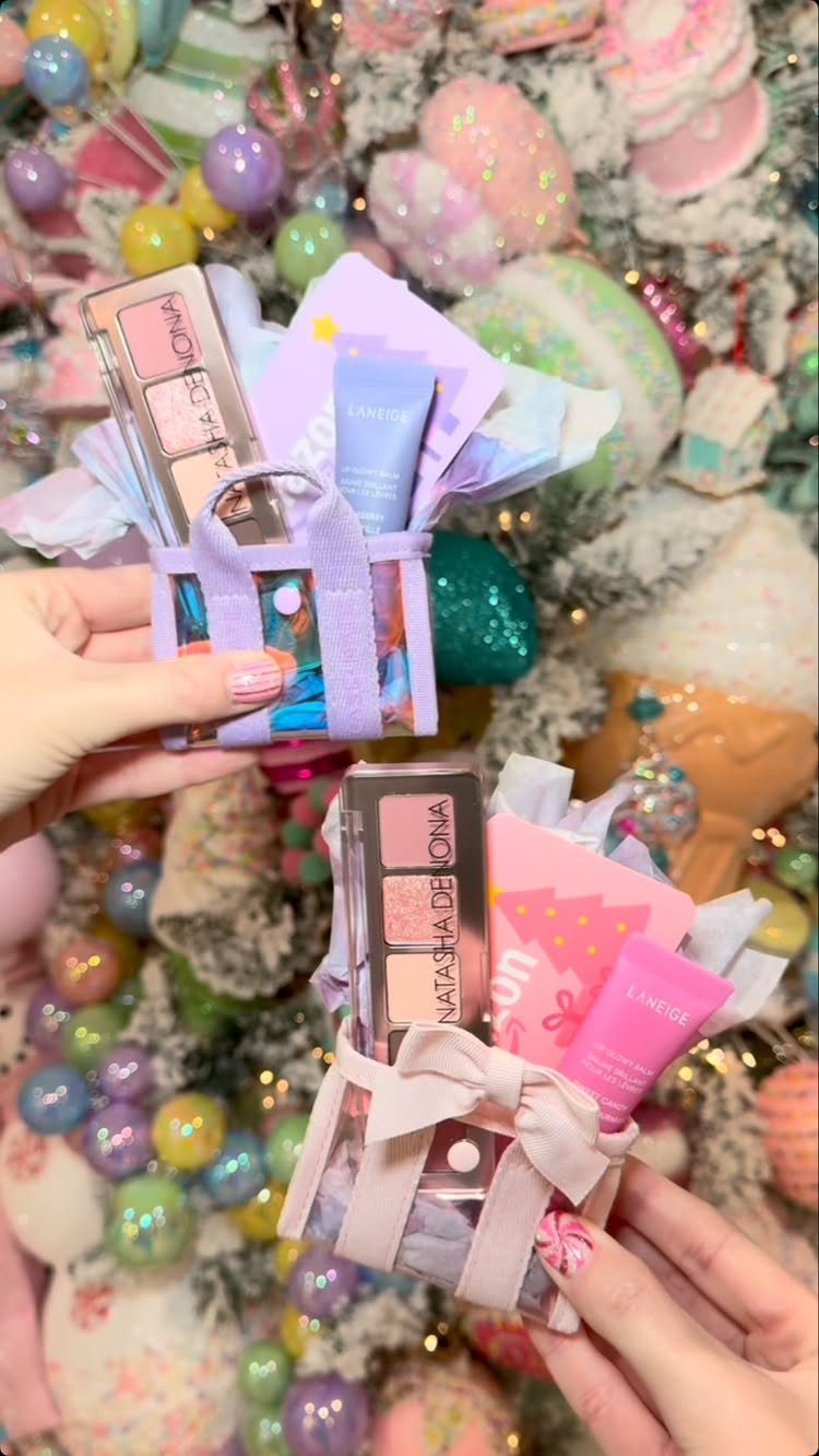 Small clear gift baskets with makeup and skincare held against a Christmas tree.