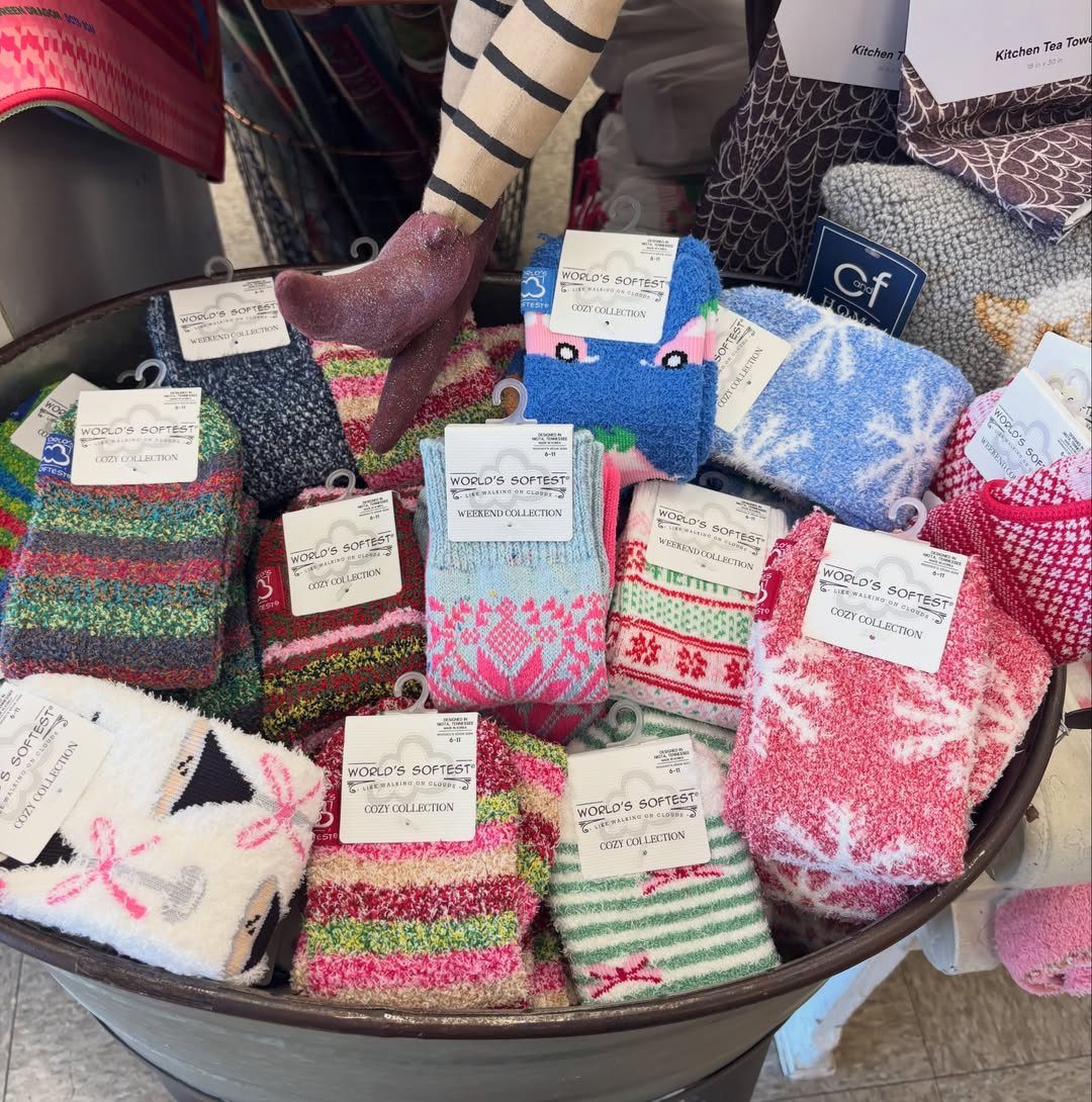Colorful fuzzy holiday socks with snowflakes and stripes in a metal tub.