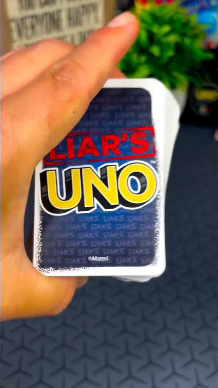 Liar's Uno card game deck held in a hand against a blurred background.
