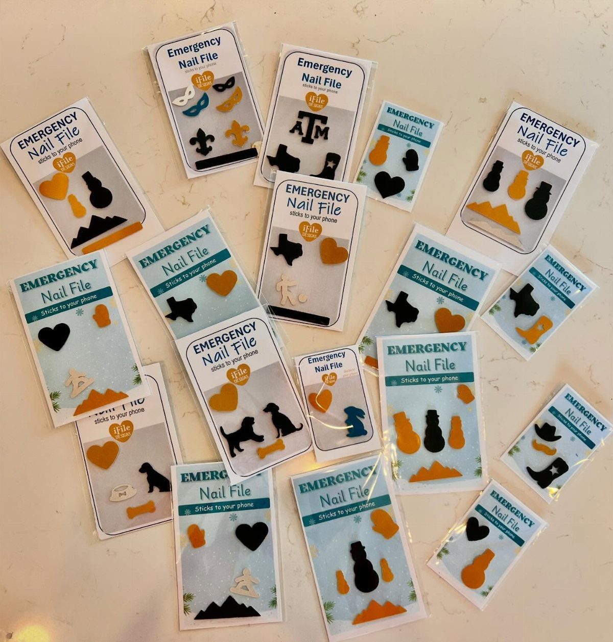 Emergency nail files in various shapes and colors in small white packages.