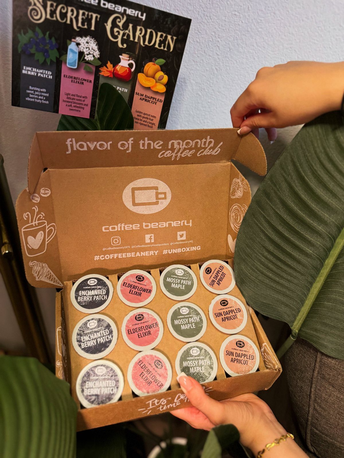 Coffee Beanery subscription box containing twelve colorful coffee pods held by a person.