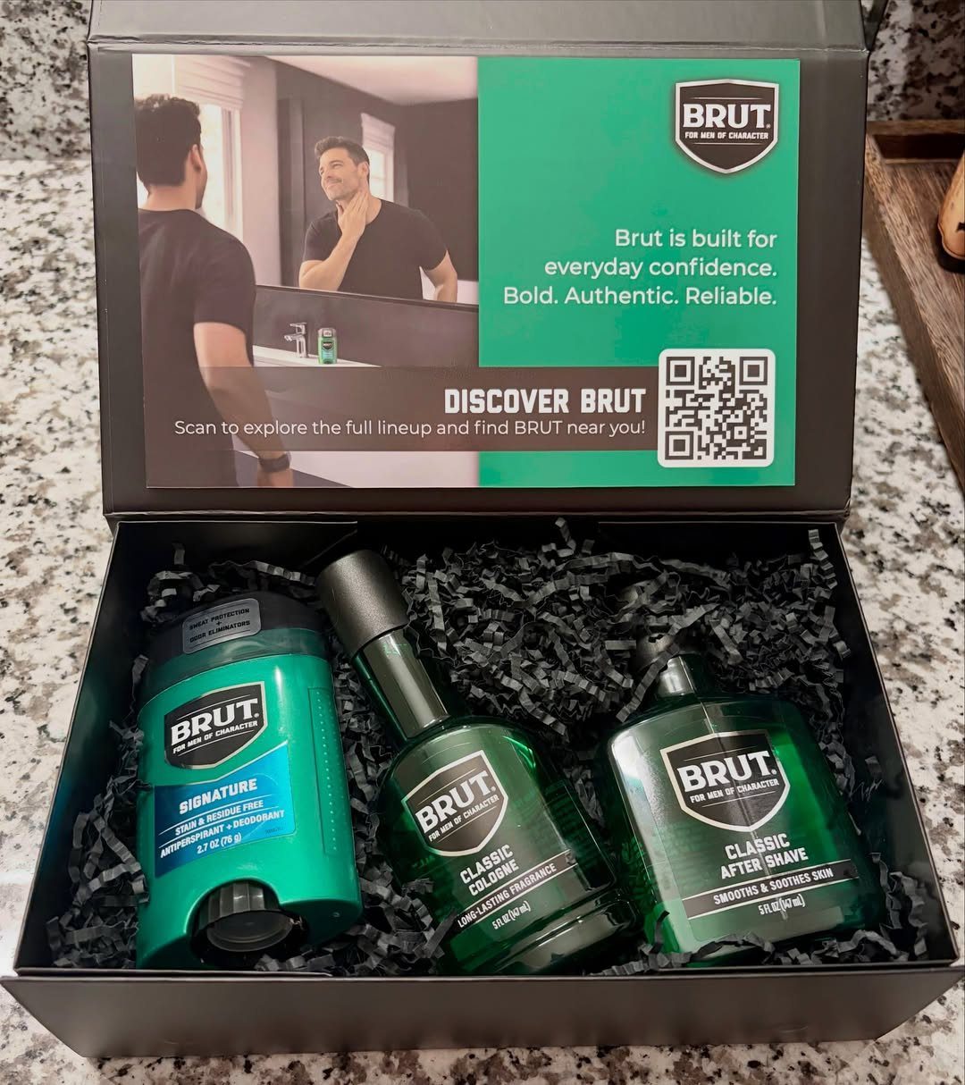 Brut grooming gift set with cologne, aftershave, and deodorant in a black box.