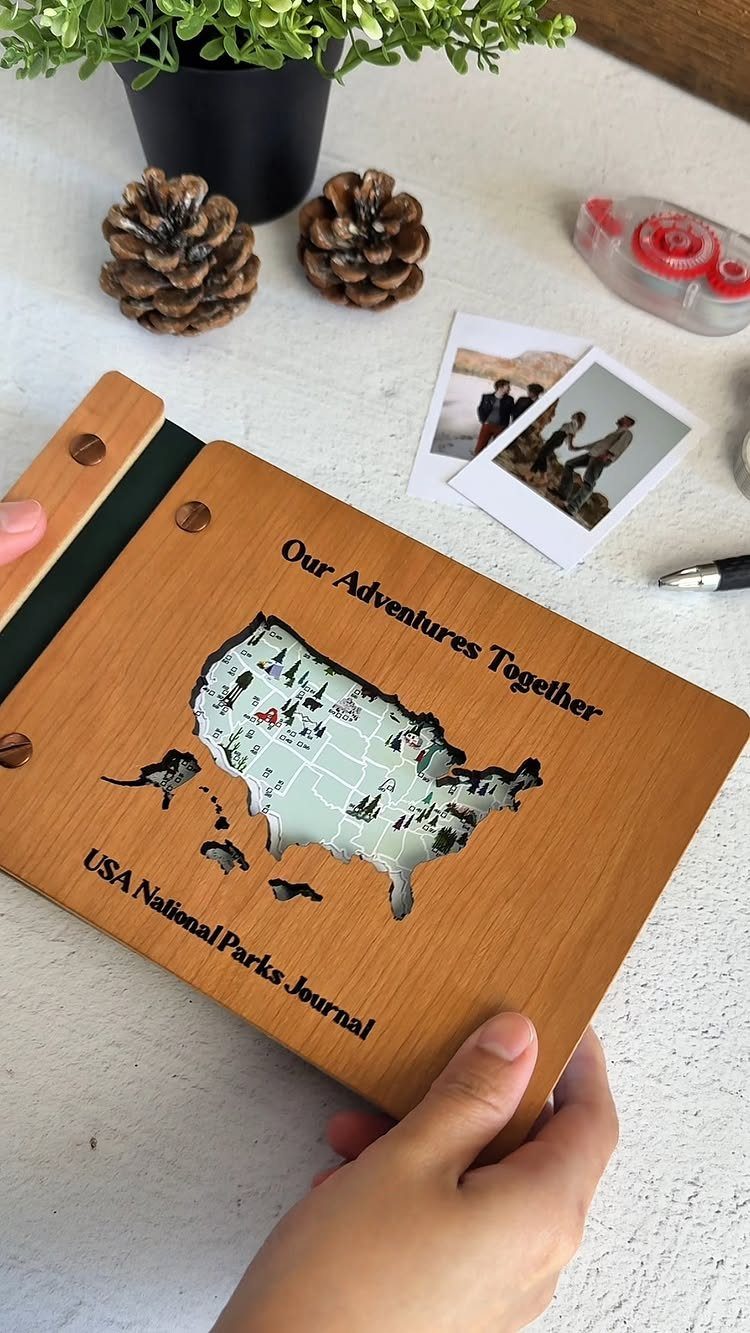 Wooden USA National Parks Journal with a map cutout and polaroid photos nearby.