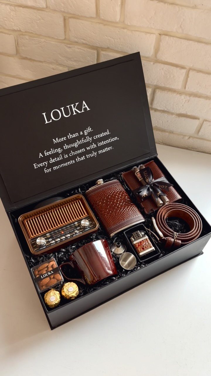 Brown themed gift box with retro radio, leather accessories, and chocolates on white background