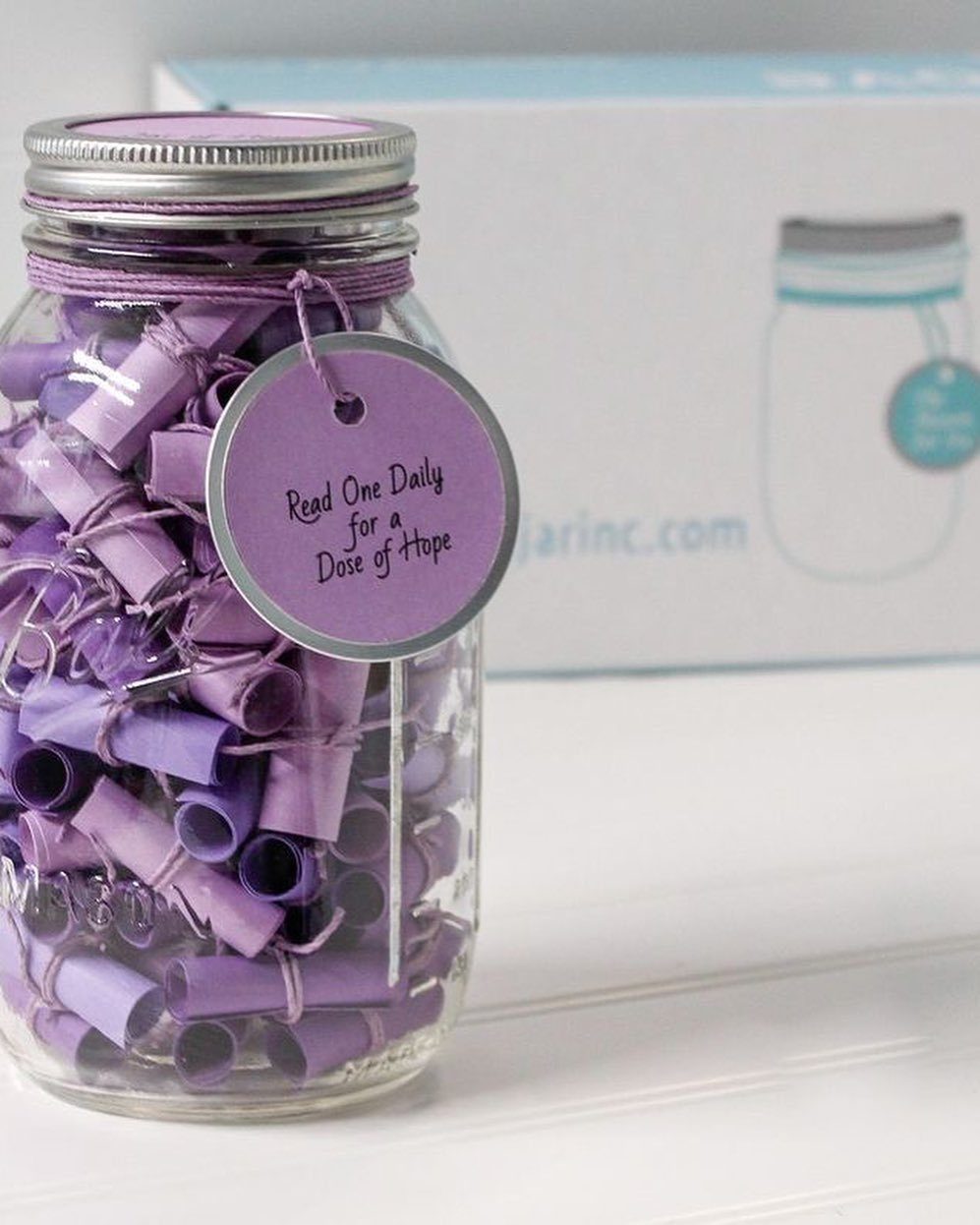 Glass jar filled with rolled purple paper messages and a hope tag.
