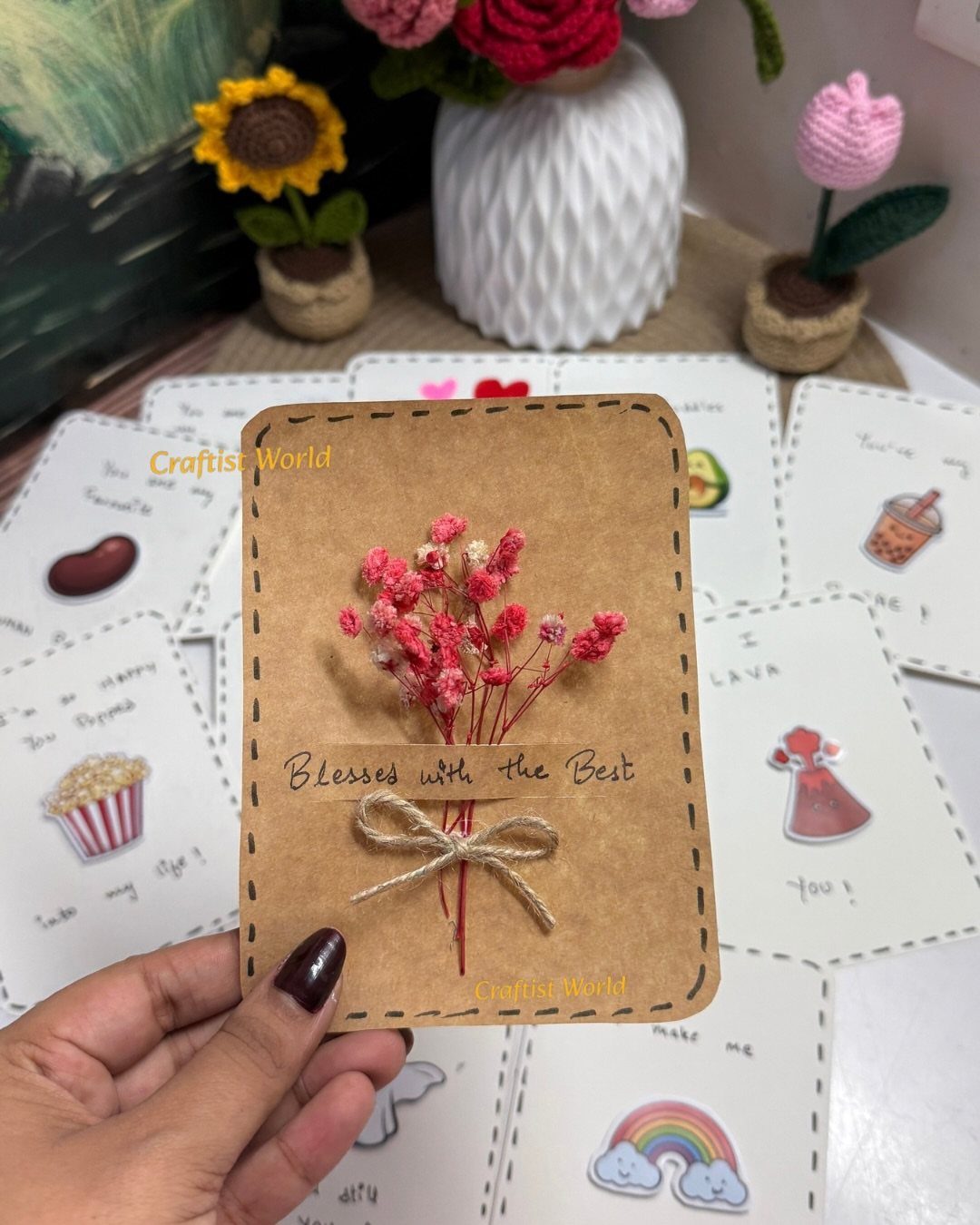Handmade brown kraft paper card with dried pink flowers and a twine bow.