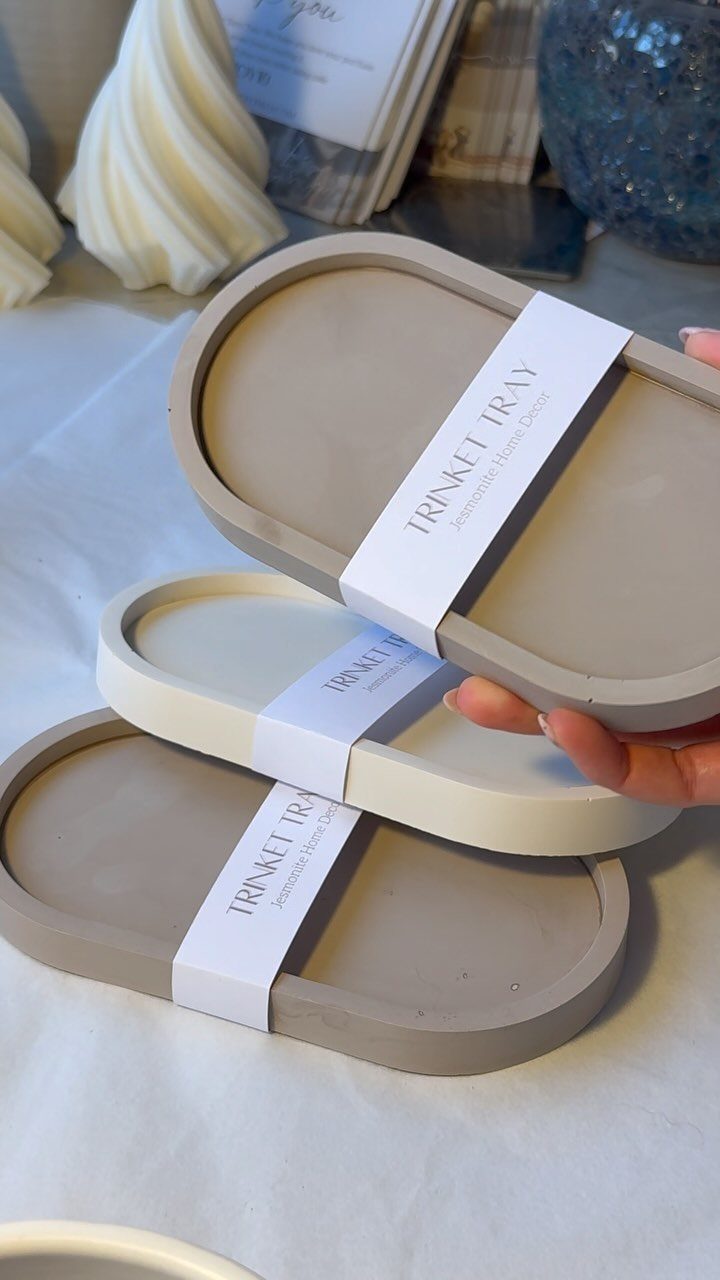 Three oval trinket trays in neutral tones with white paper labels.